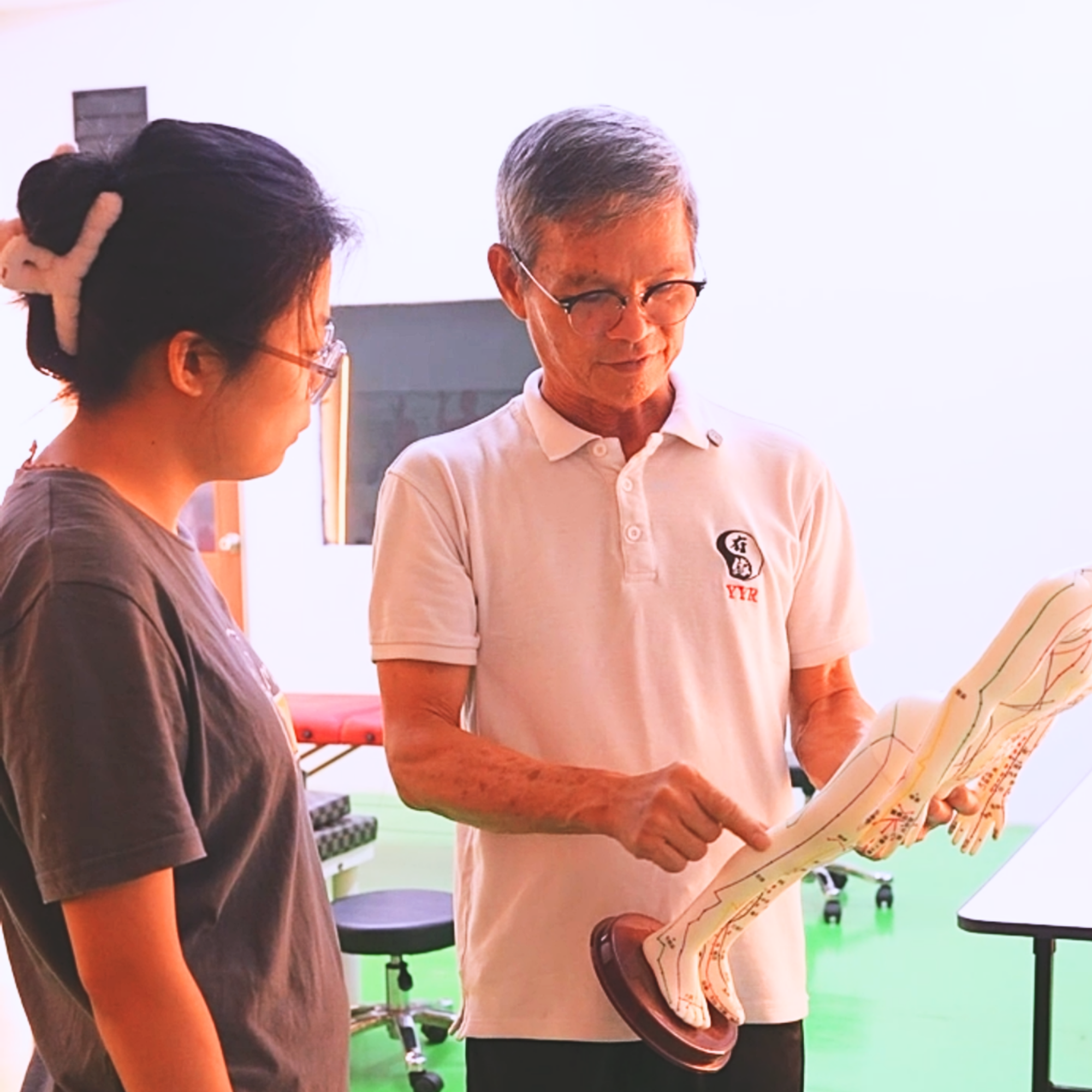 health Skills Training Centre Uncle Lim explaining Tuina using a meridian model